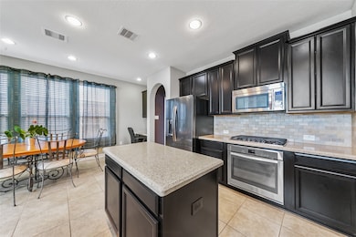 Beautiful chefs kitchen with stone tiled flooring, granite countertops, custom backsplash and gas cook top.