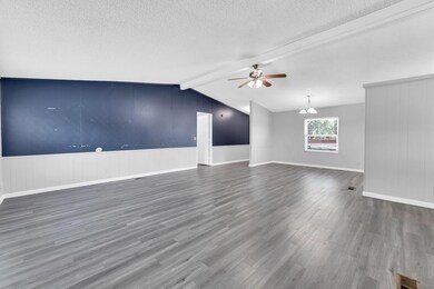 Unfurnished living room with lofted ceiling with b