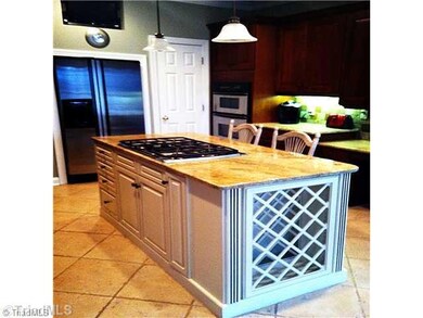 Kitchen. Enjoy preparing your meals in this custom kitchen with beautiful glazed island.  Designer Granite counters, built in wine rack and refrigerator all to the wonderful flow of this kitchen.  Add heated ceramic floors, and this is a cook s dream.