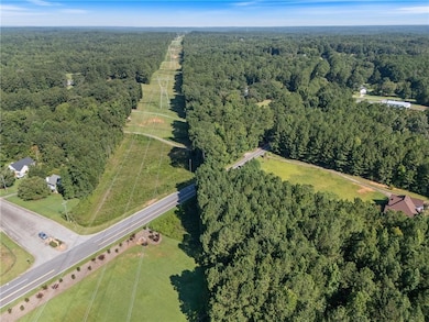 Aerial view of property and surrounding area with a forest