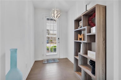 Doorway with a notable chandelier, baseboards, and