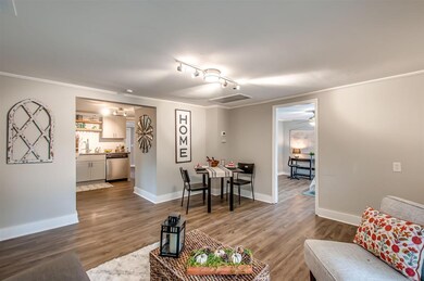 Another view of the living room showing one of the guest rooms and the kitchen.