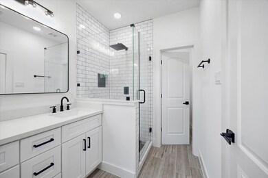 The primary suite also features a frameless subway