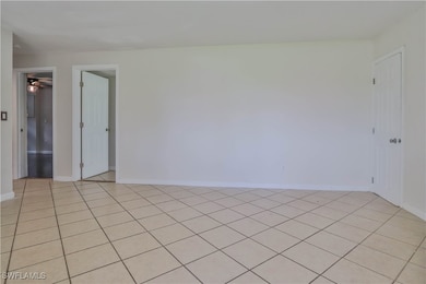 Spare room with baseboards and light tile patterne