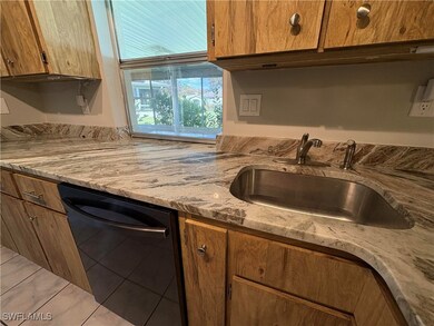 Kitchen featuring dishwasher, light stone countert