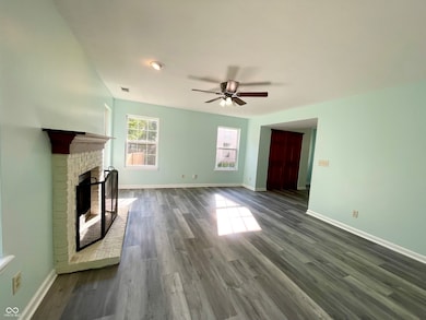 unfurnished living room with a fireplace, dark wood-type flooring, and ceiling fan