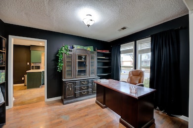 Office with a textured ceiling and light wood-type