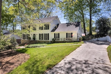 Colonial house with a front lawn and roof with shi