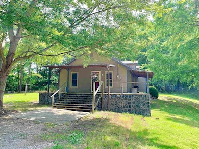 View of front of home with a porch, a front yard, and stairway