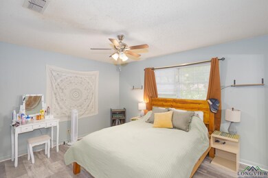 Bedroom featuring wood finished floors, a ceiling fan, and a textured ceiling