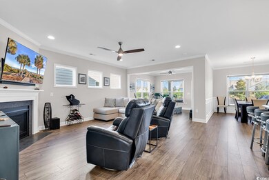 Living room featuring crown molding, ceiling fan w