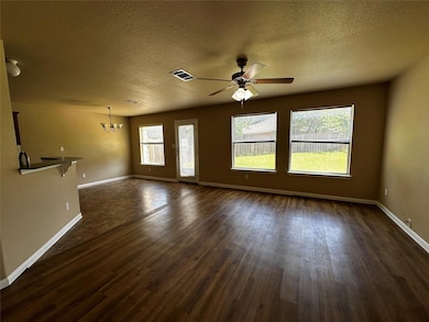 Unfurnished living room featuring a chandelier, d