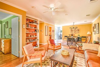Living area with crown molding, light wood-type flooring, a ceiling fan, and baseboards