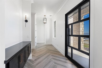 Entry featuring a chandelier, crown molding, and w