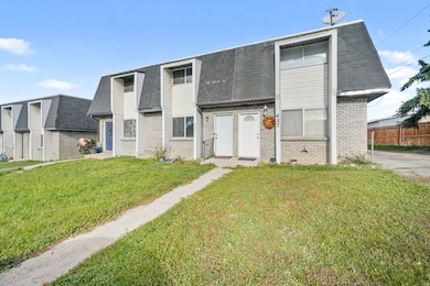 View of front of home featuring brick siding, a shingled roof, and mansard roof