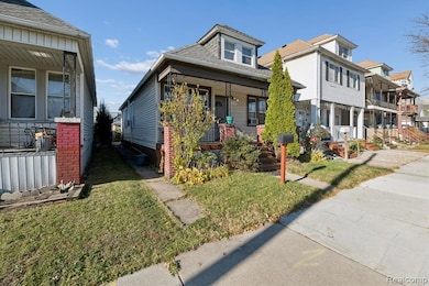 View of front of home with a front yard, covered porch, and roof with shingles