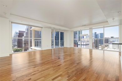 Unfurnished room featuring a view of skyline, expansive windows, and light wood-type flooring