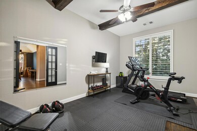 Living room featuring a stone fireplace, beam ceil