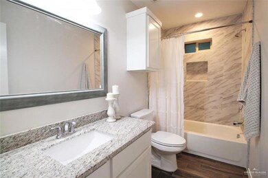 Full bath featuring shower / tub combo, vanity, toilet, wood finished floors, and recessed lighting