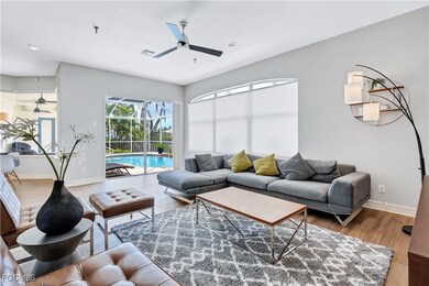Living room featuring light wood-style floors, a ceiling fan, and a sunroom