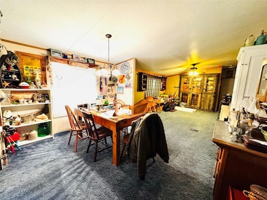 Carpeted dining area with a textured ceiling and a