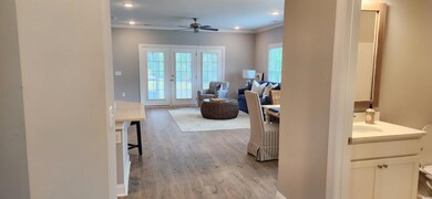 Living room with ceiling fan, ornamental molding, 