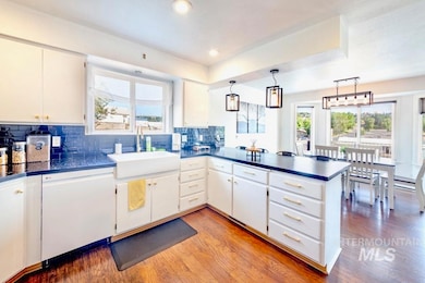 Kitchen featuring dark countertops, a peninsula, light wood-style flooring, and recessed lighting