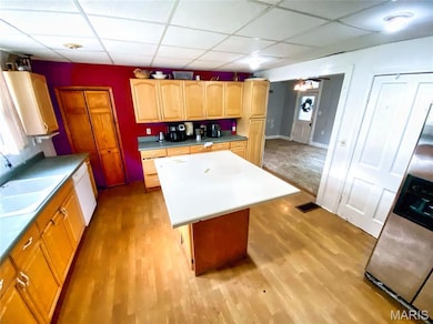 Kitchen with a kitchen island, a drop ceiling, light wood finished floors, stainless steel refrigerator with ice dispenser, and white dishwasher