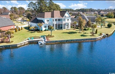 Back of house featuring a water view, a balcony, a
