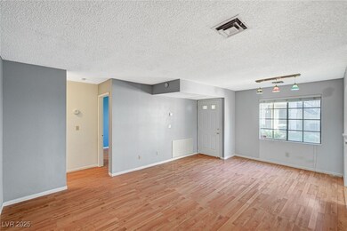 Empty room with light wood-style floors, visible v