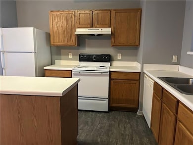 Kitchen with brown cabinetry, light countertops, u