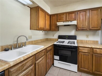 Kitchen with gas stove, under cabinet range hood,