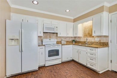 Kitchen with white appliances, a sink, white cabin