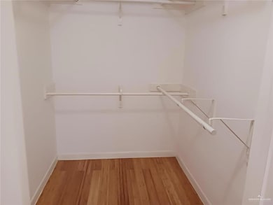 Walk in closet with light wood-style flooring