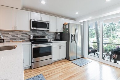 Kitchen with appliances with stainless steel finishes, a sink, decorative backsplash, ornamental molding, and light wood finished floors