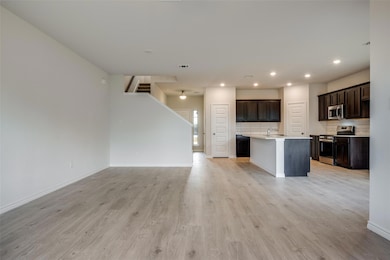 Kitchen with a center island with sink, light hard