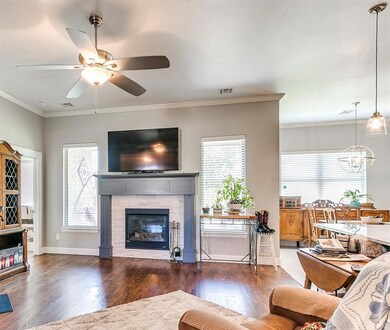 Living room featuring ceiling fan, ornamental mold