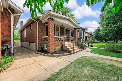View of front of home with brick siding, a porch, and a front yard