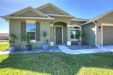 View of front of home featuring stucco siding, an attached garage, and a front lawn