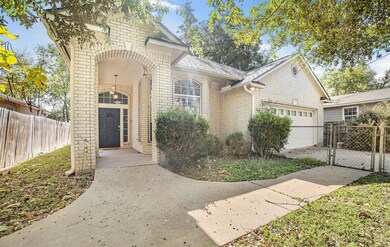 View of front facade with a gate, brick siding, an attached garage, concrete driveway, and roof with shingles