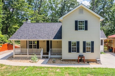 View of front of home featuring roof with shingles, a porch, and a chimney