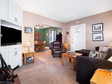 Carpeted living room with ceiling fan