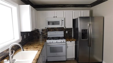 Kitchen decorative backsplash, white cabinets, and