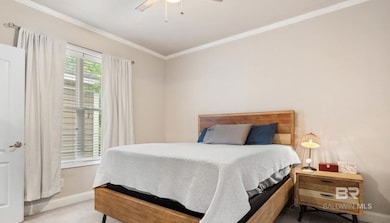 Bedroom with crown molding, carpet, and a ceiling fan
