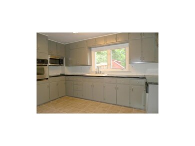 KITCHEN HAS BLACK CONCRETE COUNTERTOPS AND STAINLE