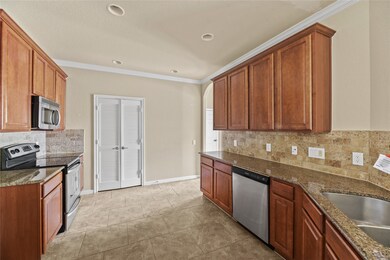 Spacious kitchen featuring elegant wood cabinetry, modern stainless steel appliances, and sleek granite countertops—perfect for culinary enthusiasts.