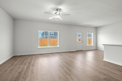 Unfurnished living room with light wood-style floors, plenty of natural light, and a ceiling fan