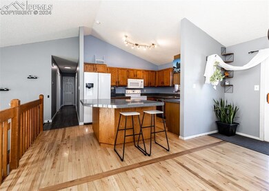Kitchen with a breakfast bar, white appliances, a 