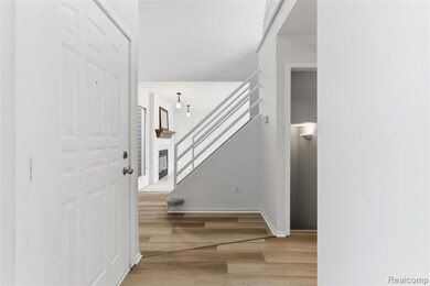 Entrance foyer with light wood finished floors, stairs, and a glass covered fireplace
