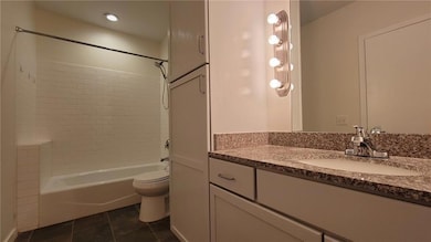 Full bath with vanity, bathtub / shower combination, and tile patterned flooring